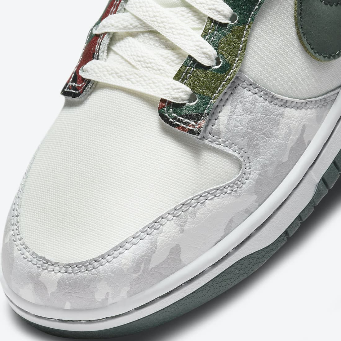 Nike Dunk Low - Vue latérale de la sneaker blanche avec empiècements camouflage beige et marron, swoosh vert olive et semelle bicolore