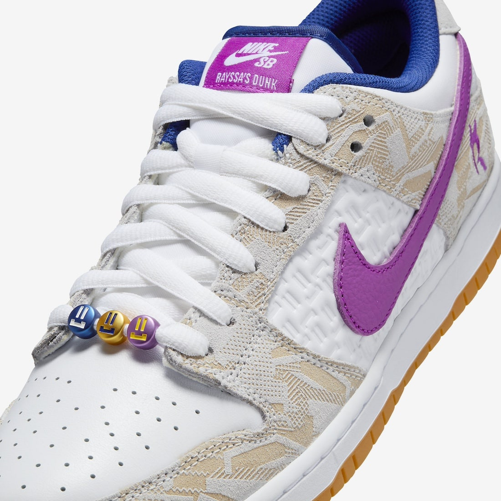 Nike SB Dunk Low Rayssa Leal - Vue latérale de la sneaker blanche avec empiècements beige et swoosh bleu royal, semelle gomme jaune