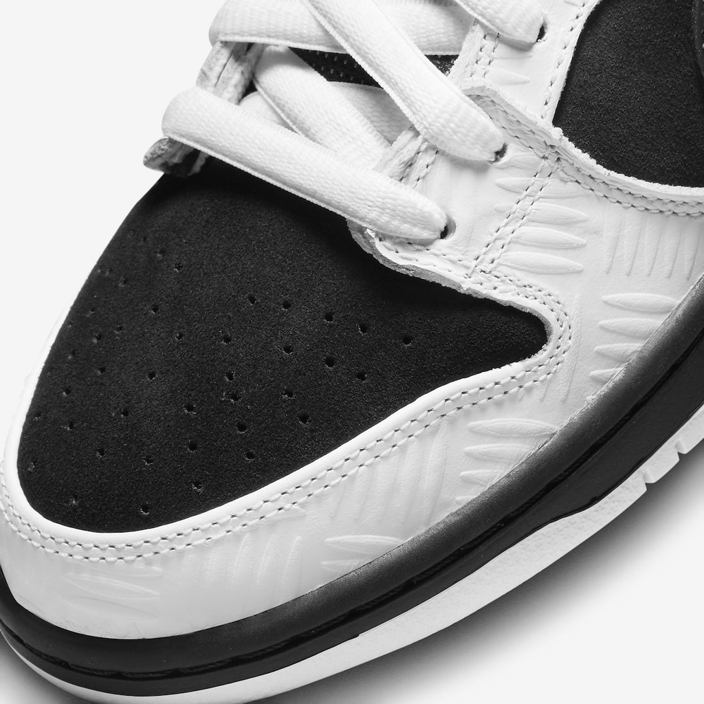 Nike SB Dunk Low TIGHTBOOTH - Vue latérale de la sneaker noir et blanc avec swoosh gris, détail orange sécurité et semelle noire