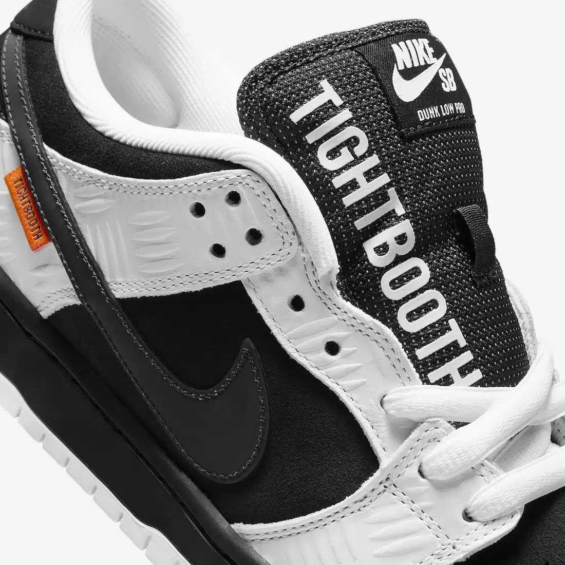 Nike SB Dunk Low TIGHTBOOTH - Vue latérale de la sneaker noir et blanc avec swoosh gris, détail orange sécurité et semelle noire