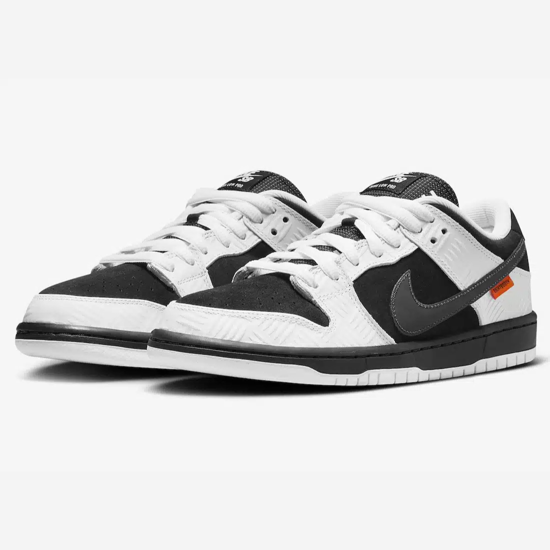 Nike SB Dunk Low TIGHTBOOTH - Vue latérale de la sneaker noir et blanc avec swoosh gris, détail orange sécurité et semelle noire